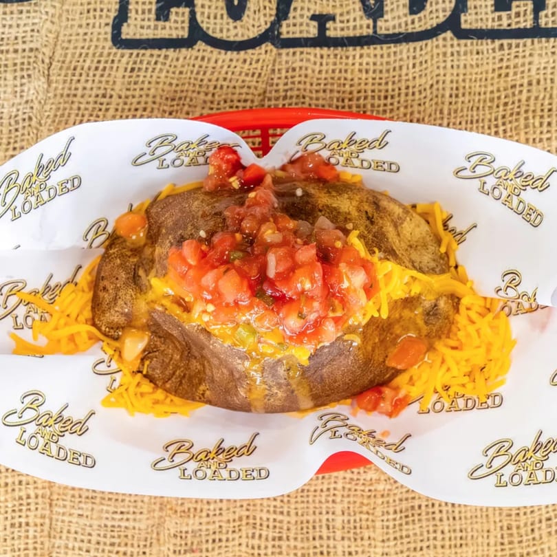 Baked potato from Baked and Loaded, topped with shredded cheddar cheese and salsa.